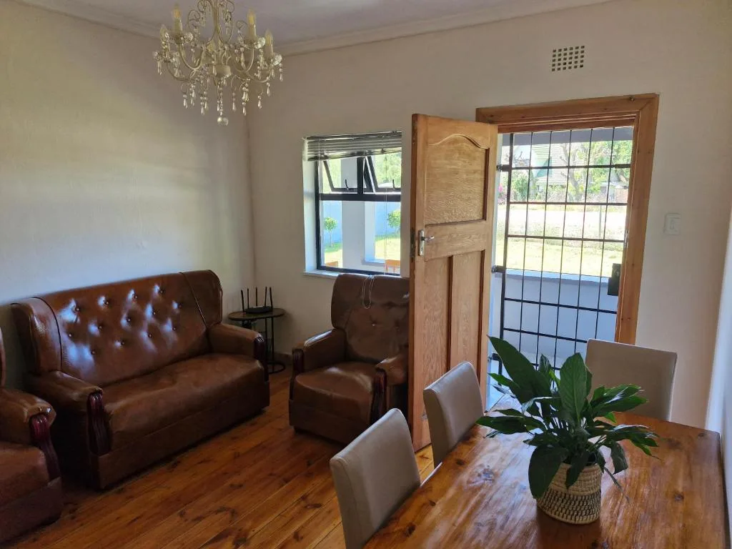 Open-plan lounge with leather sofa, armchair, and dining area visible