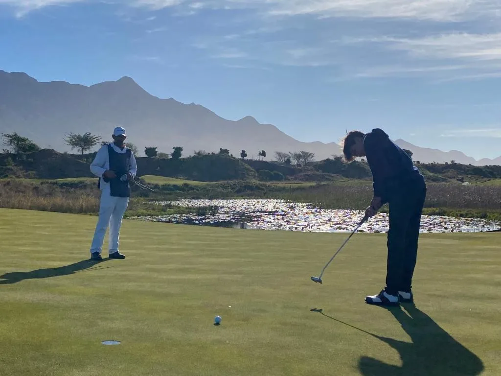 Golf course with mountain backdrop and water hazard scenery