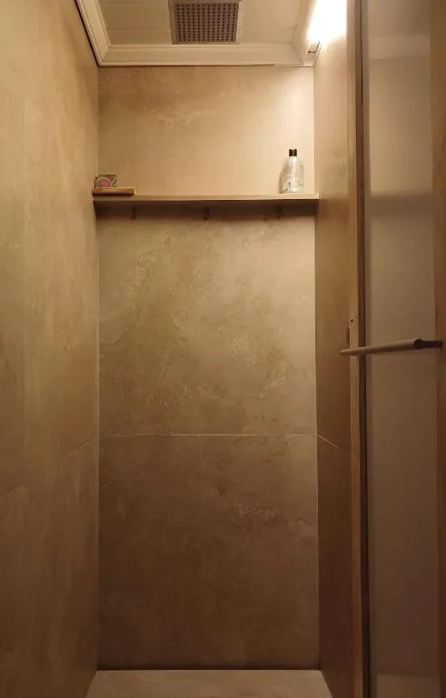 Modern walk-in shower enclosure with tiled walls and chrome fixtures