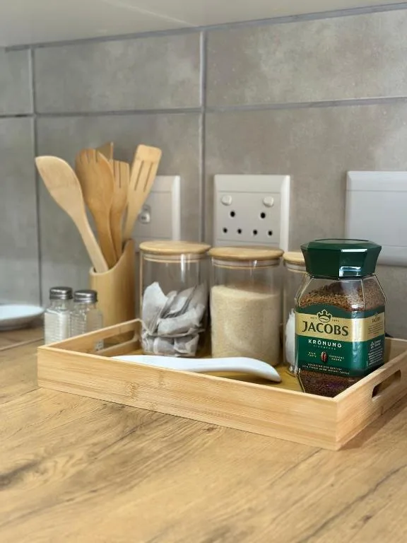 Kitchen counter organized with wooden utensil holder and storage containers