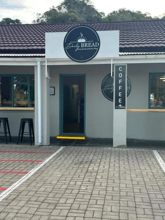 Modern white storefront with dark signage and patterned tile entrance