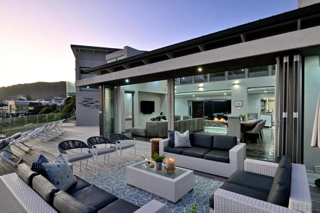 Modern outdoor deck with lounge seating and contemporary furniture overlooking valley