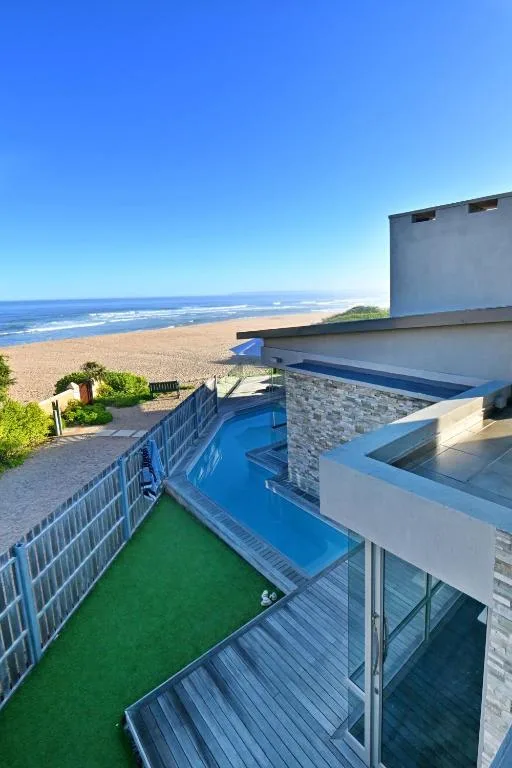 Beachfront swimming pool with ocean and sandy beach views beyond