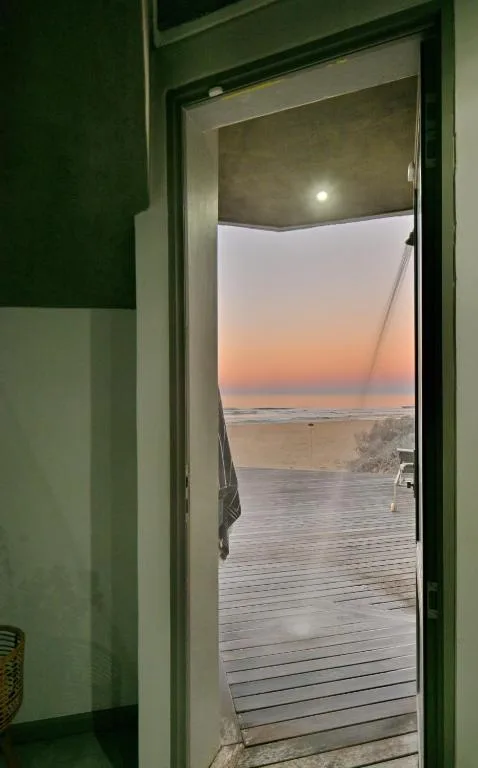 Sunset over the ocean and beach viewed through an open doorway