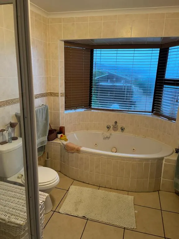 Spacious bathroom with corner jacuzzi tub and large window