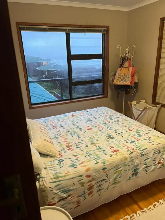 Bedroom with double bed and panoramic window overlooking scenic mountain landscape
