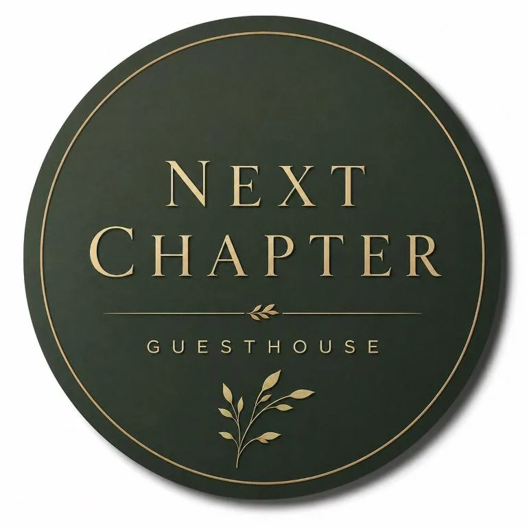 Next Chapter Guesthouse circular green sign with gold lettering and botanical design