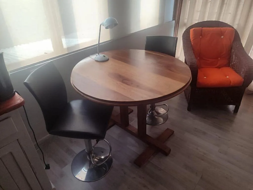 Modern lounge area with round wooden table and colorful seating chairs