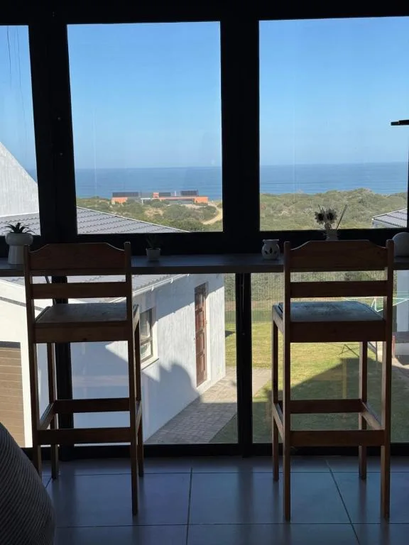 Ocean and coastal landscape view through large windows from interior
