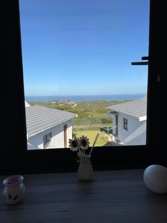 Ocean and coastal landscape visible through window with modern buildings