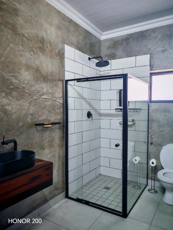 Modern bathroom with black-framed shower enclosure and white subway tiles