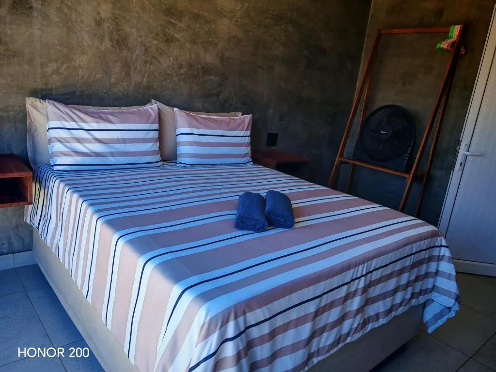 Bedroom with striped blue and white bedding and decorative blue towels