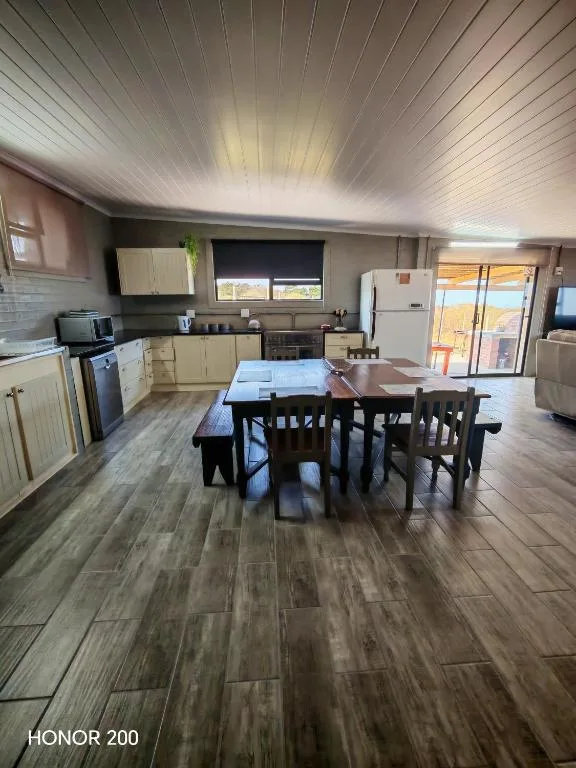 Open-plan kitchen and dining area with wooden table and chairs