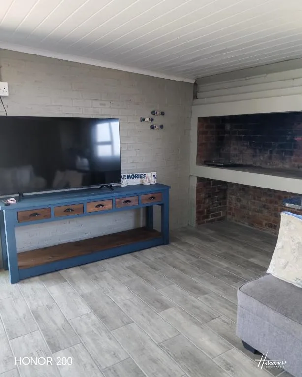 Living room with blue TV unit and brick fireplace accent wall
