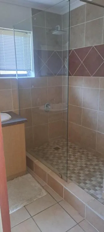 Modern walk-in shower with glass enclosure and neutral tile finishes