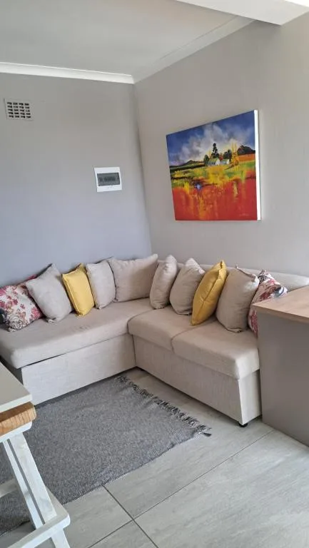 Spacious lounge with cream corner sofa and colorful scatter cushions