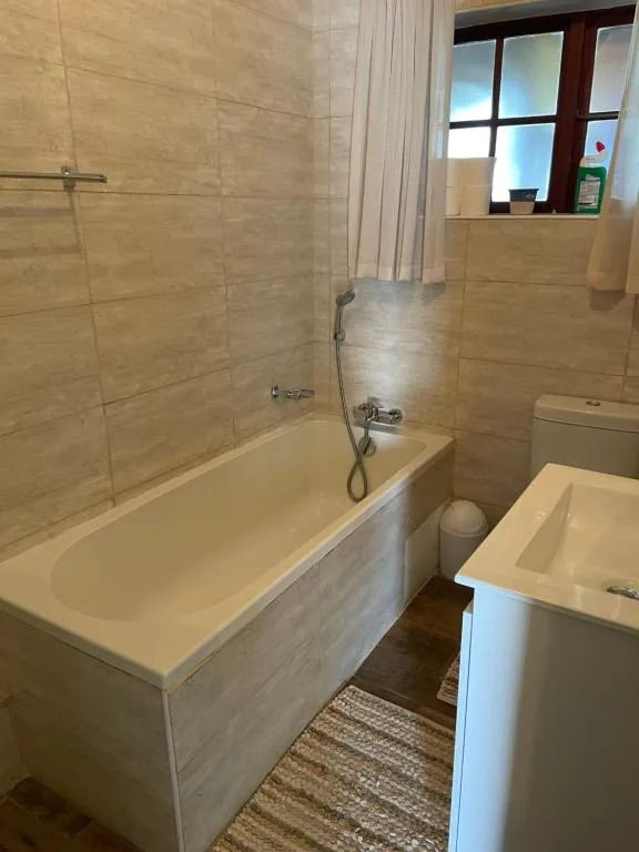 Modern bathroom with bathtub, shower enclosure, and white vanity sink