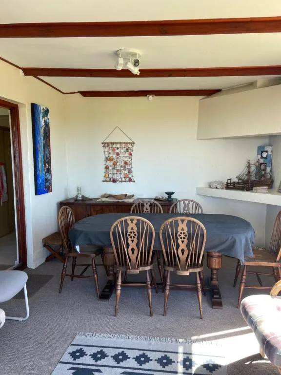 Dining area with round table and wooden chairs, exposed beams