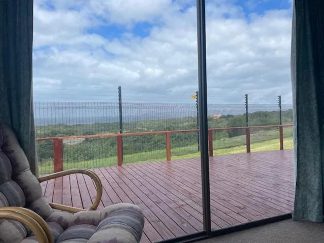 Panoramic landscape view from elevated deck with rolling hills and distant ocean