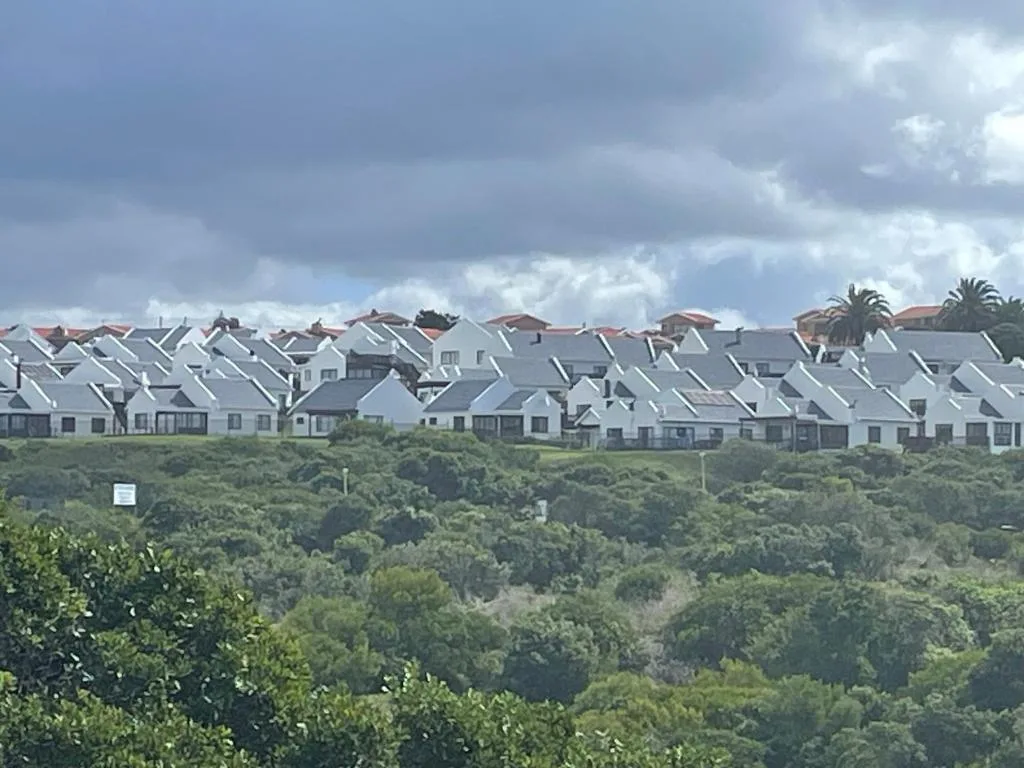 Cluster of white-roofed houses nestled in lush green valley landscape