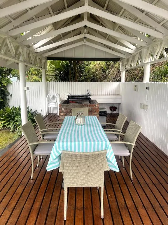 Covered outdoor dining area with table, chairs, and brick braai