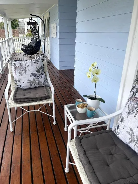 Covered deck with comfortable seating, potted orchid, and ocean views