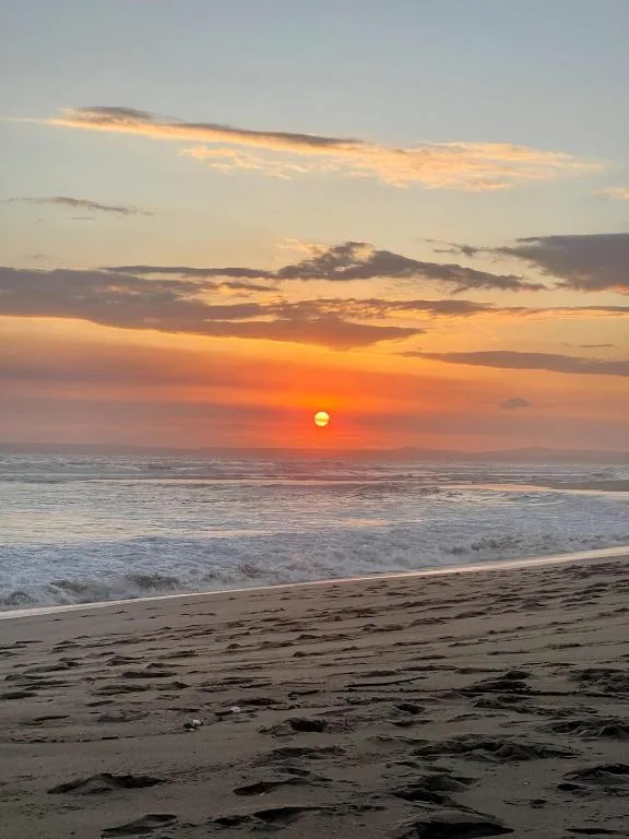 Stunning golden sunset over the ocean with waves and sandy beach