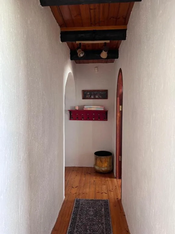 Hallway with wooden beams, red shelf, and decorative wooden oar