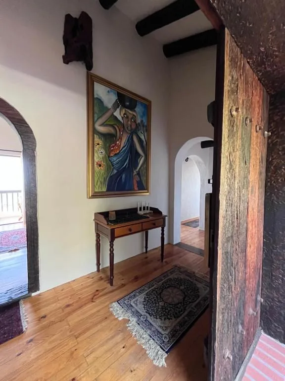 Entrance hallway with wooden console table, framed artwork, exposed beams