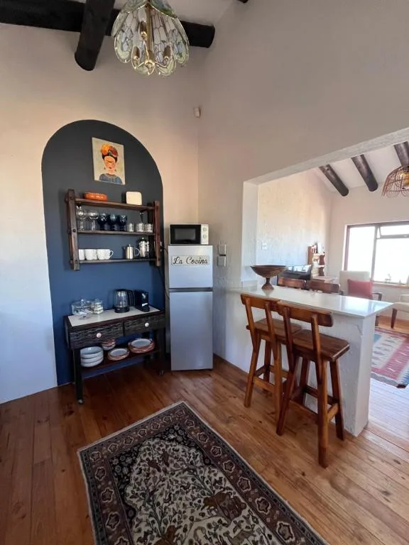 Modern kitchen with blue arched alcove, white fridge, and wooden bar seating