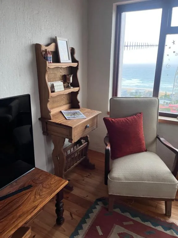 Lounge corner with cream armchair and ocean view through windows
