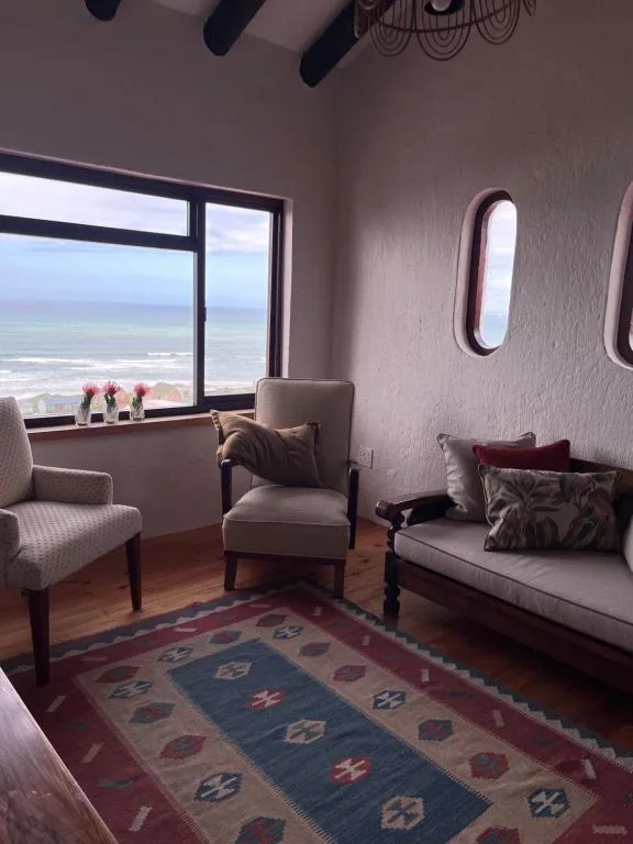 Coastal lounge with ocean view through large windows and comfortable seating