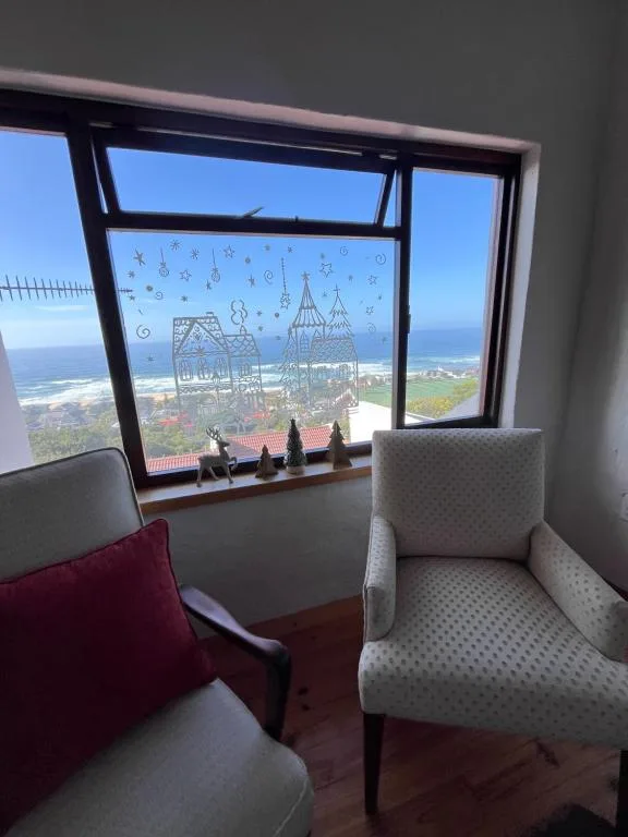 Panoramic coastal vista through large windows with decorative cutouts