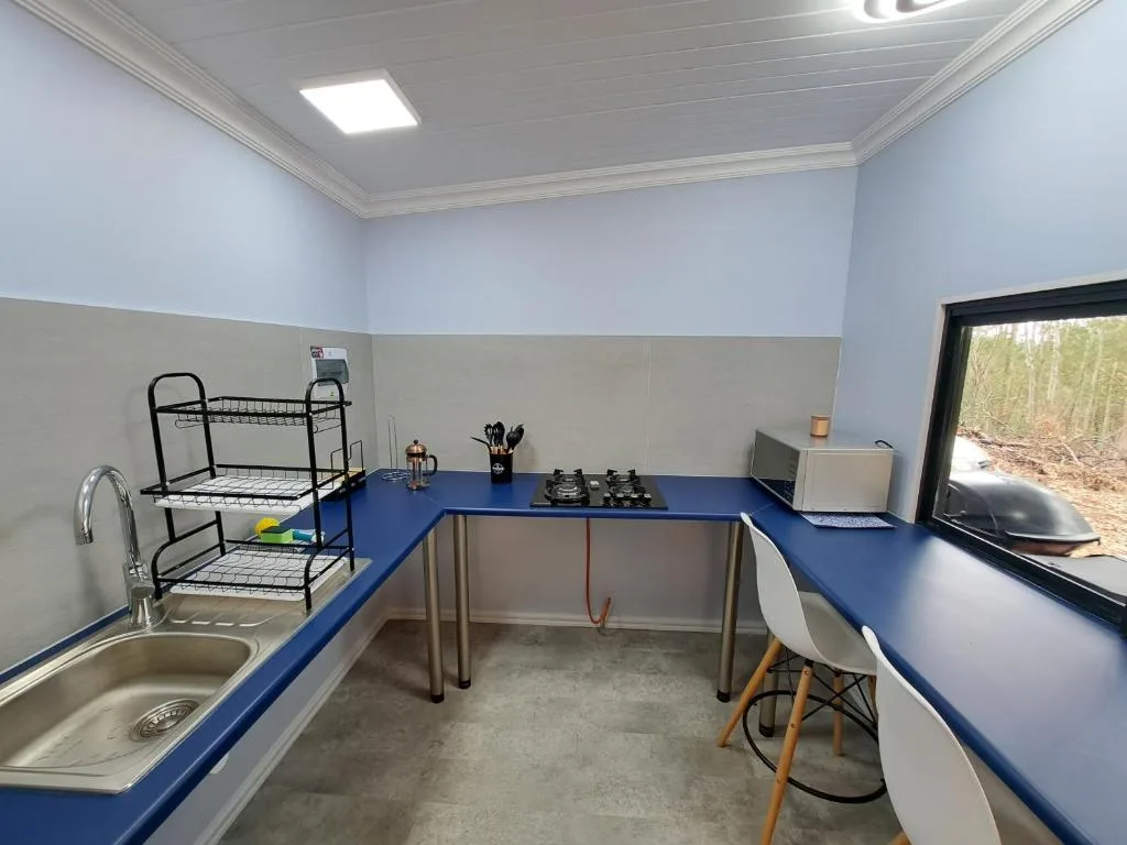 Modern kitchen with blue countertops, gas cooktop, sink, and dining workspace