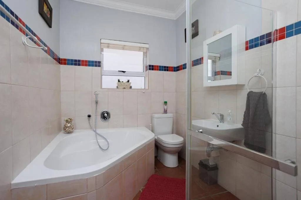 Bathroom with curved bathtub, toilet, sink vanity, and shower enclosure