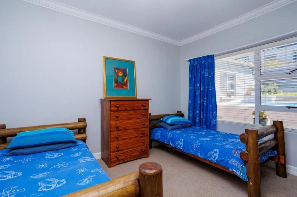 Bright bedroom with two wooden beds dressed in blue nautical bedding