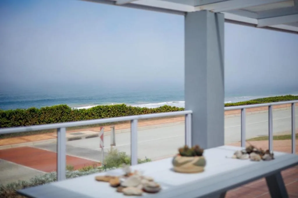 Ocean and beach view from covered deck with coastal landscape