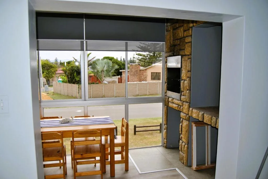 Outdoor patio area with dining table and garden views through open doors