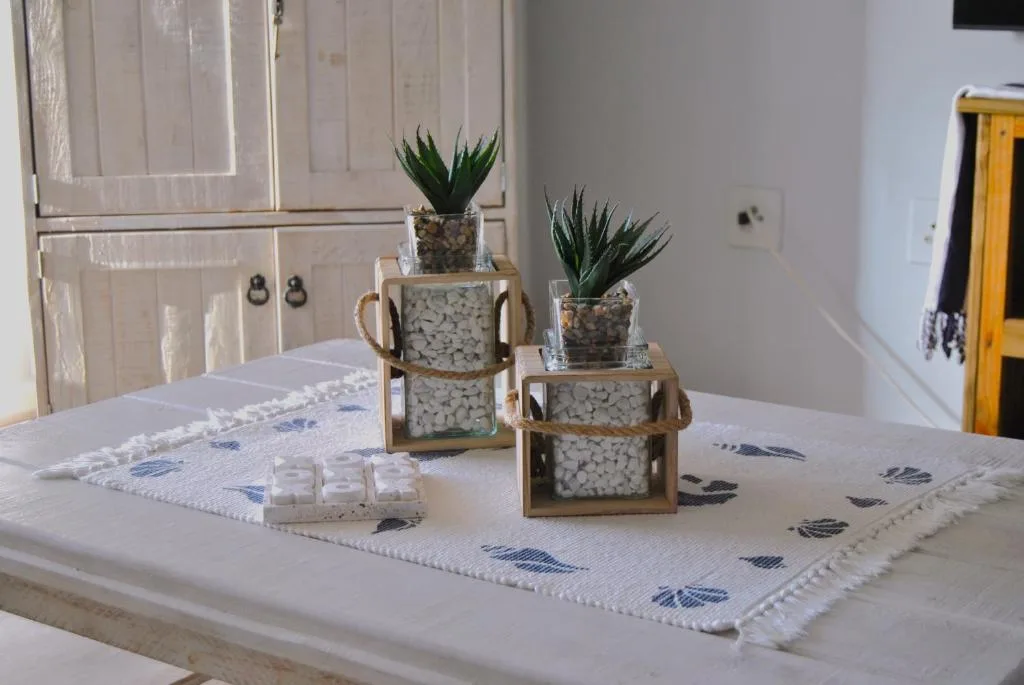 Decorative table arrangement with potted succulents and patterned table runner