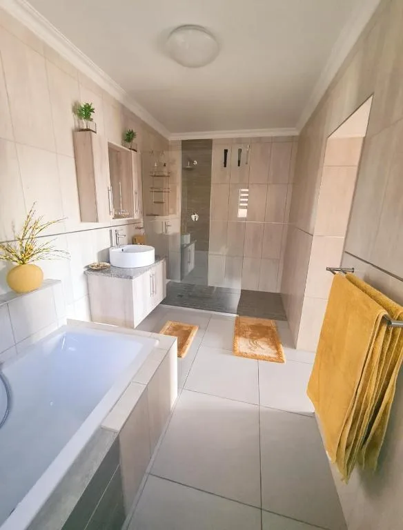 Modern bathroom with bathtub, vanity sink, and walk-in shower area