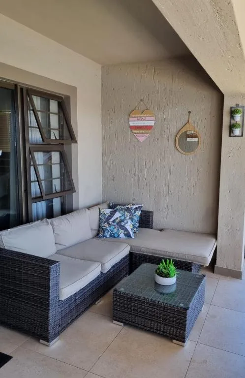 Outdoor seating area with dark wicker furniture and cushions