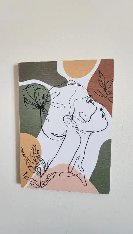 Abstract line art wall decor featuring stylized faces and botanical elements