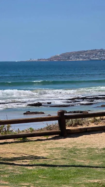 Ocean waves and coastal town visible from beachfront property deck