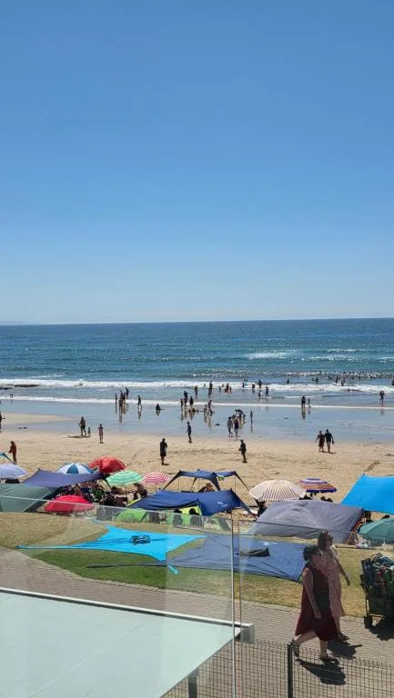 Pristine beach with ocean waves, golden sand, and clear blue sky