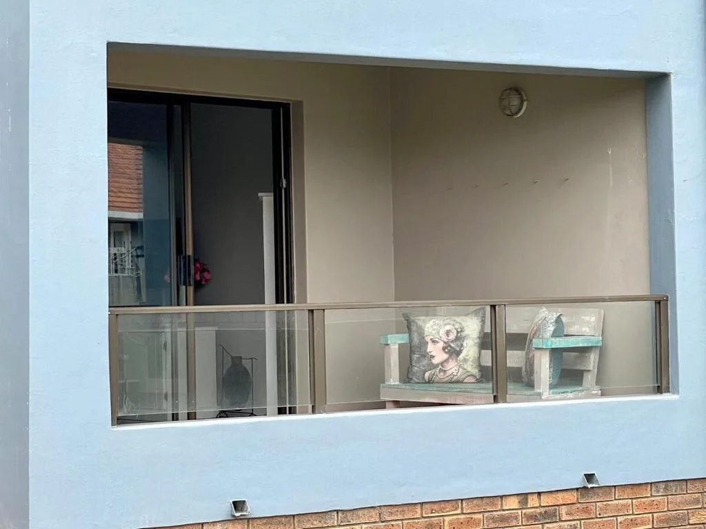 Modern balcony with glass railing and decorative coastal-themed shelving display