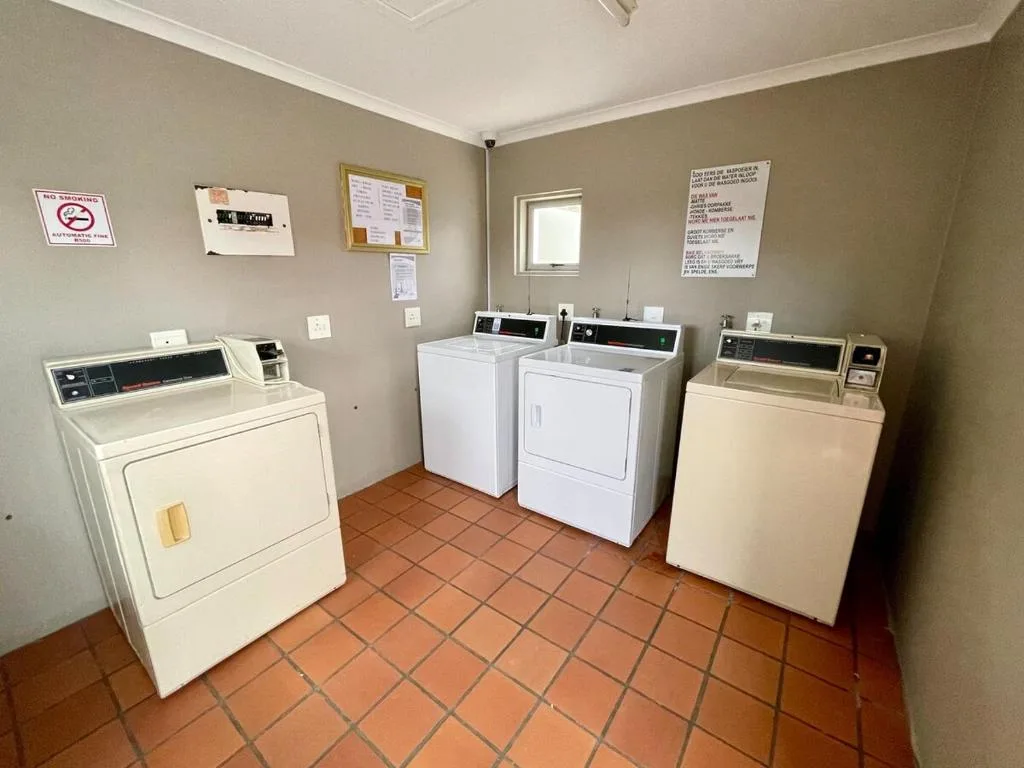 Shared laundry room with multiple washers and dryers