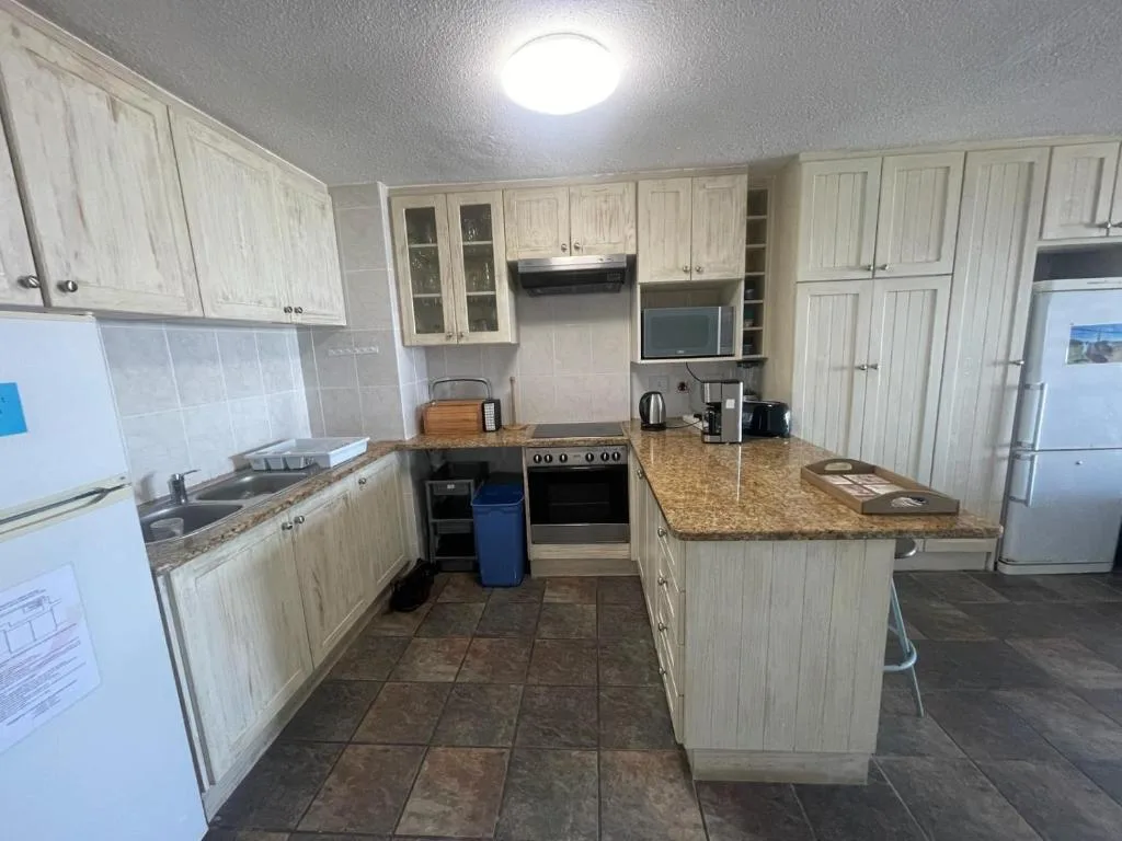 Spacious kitchen with cream cabinetry, granite countertops, and stainless steel appliances