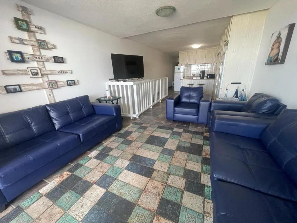 Open-plan lounge with blue leather seating and flat-screen television