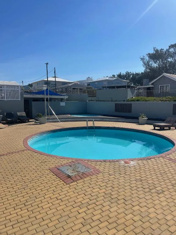 Circular swimming pool with bright blue water and brick surround