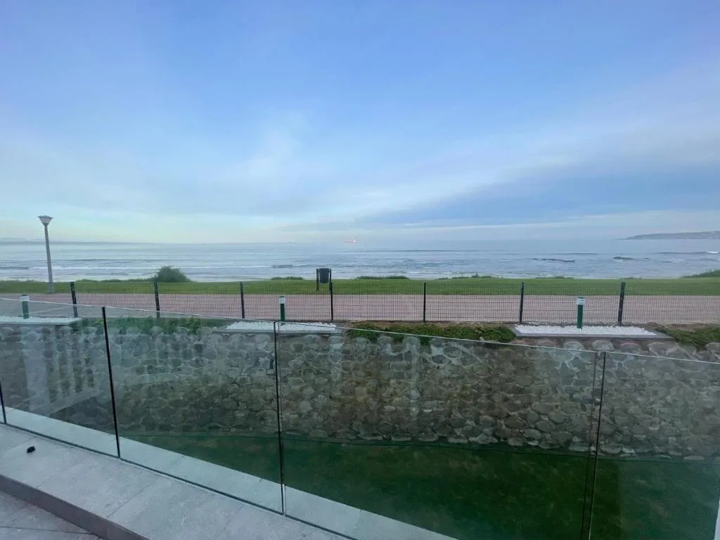 Panoramic coastal view of calm ocean and distant mountains from property